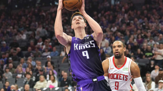 Mar 10, 2024; Sacramento, California, USA; Sacramento Kings guard Kevin Huerter (center) shoots against Houston Rockets forward Dillon Brooks (right) during the first quarter at Golden 1 Center. Mandatory Credit: Darren Yamashita-USA TODAY Sports